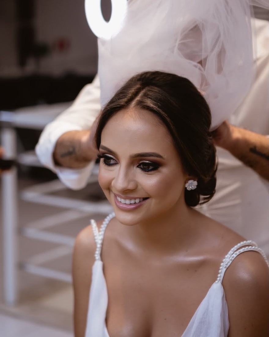 Profissional do salão Roberto Rodriguez colocando o véu na noiva, com penteado e maquiagem prontos